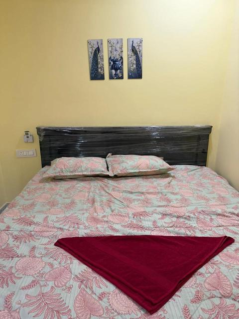 Double bed with floral bedding and wall art