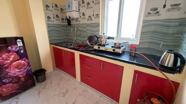 Kitchen with red cabinets, gas stove and refrigerator