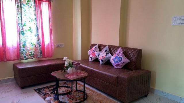 Living room with sofa, cushions and curtains