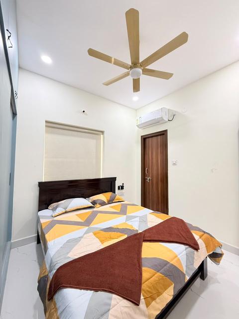 Gowlidoddi 2BHK bedroom with double bed, air conditioner and ceiling fan