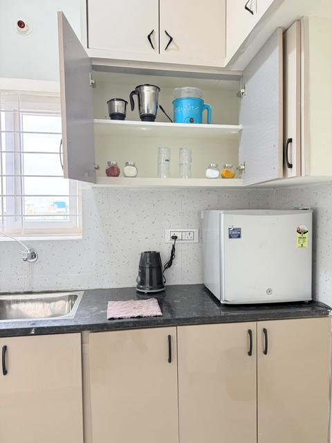 Kitchen with mini fridge, kettle, mixer and cabinets