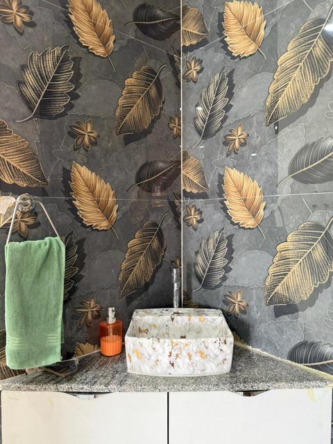 Vessel washbasin on granite vanity with leaf-pattern feature wall