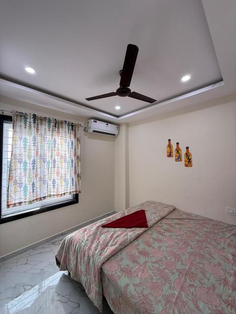 Bedroom with double bed, air conditioner and curtains