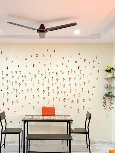 Dining area with floral accent wall and wall shelves