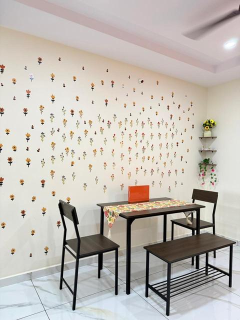 Dining table with chairs and bench against a floral accent wall