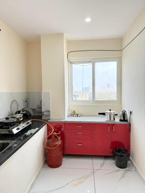 Penthouse kitchen with red cabinets, gas stove and window