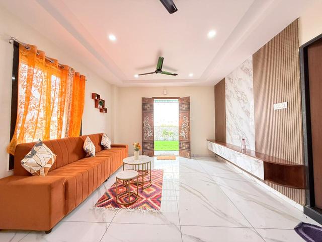 Penthouse living room with orange sofa and marble-finish flooring