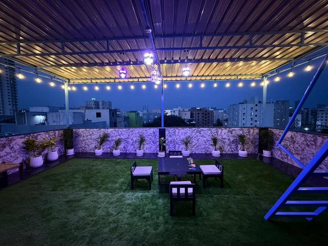 Gowlidoddi penthouse rooftop terrace with string lights and city view at dusk